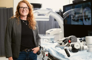 A photo of Capstan Medical CEO Maggie Nixon posing with the structural heart startup's robotic catheter delivery system.