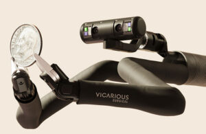 Vicarious Surgical's robot holding a dime to show its miniature size.
