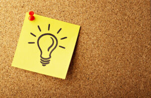 This is an Unsplash image showing a sticky note with a lightbulb drawn on it to show design thinking for medtech that promotes product stickiness.