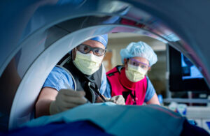 A photo of clinicians tending to a patient inside a CT scan.