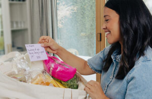 A photo of Gina Rodriguez receiving a package after using Philips Share the Care Connector tool.