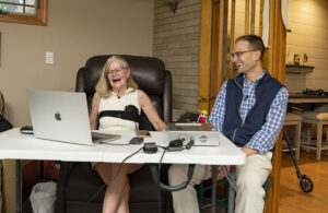 The study's first participant sits with investigator Matthew Willsey as she uses the Paradromics brain-computer interface.